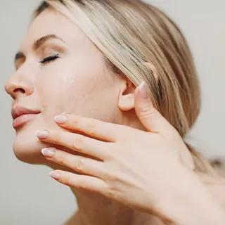 mujer tocandose la cara con ojos cerrados